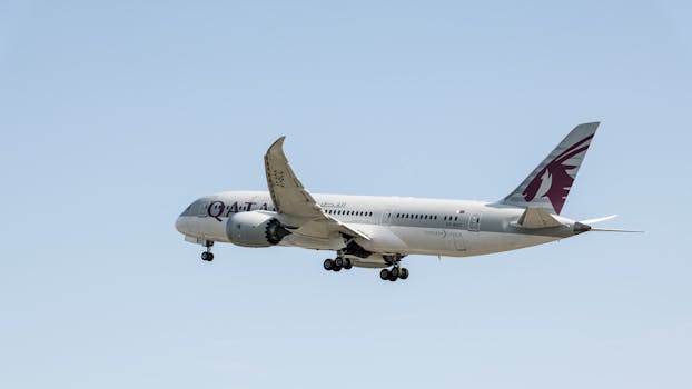 Qatar Airways Boeing 787 Dreamliner mid-air over Prague, Czech Republic's clear sky.