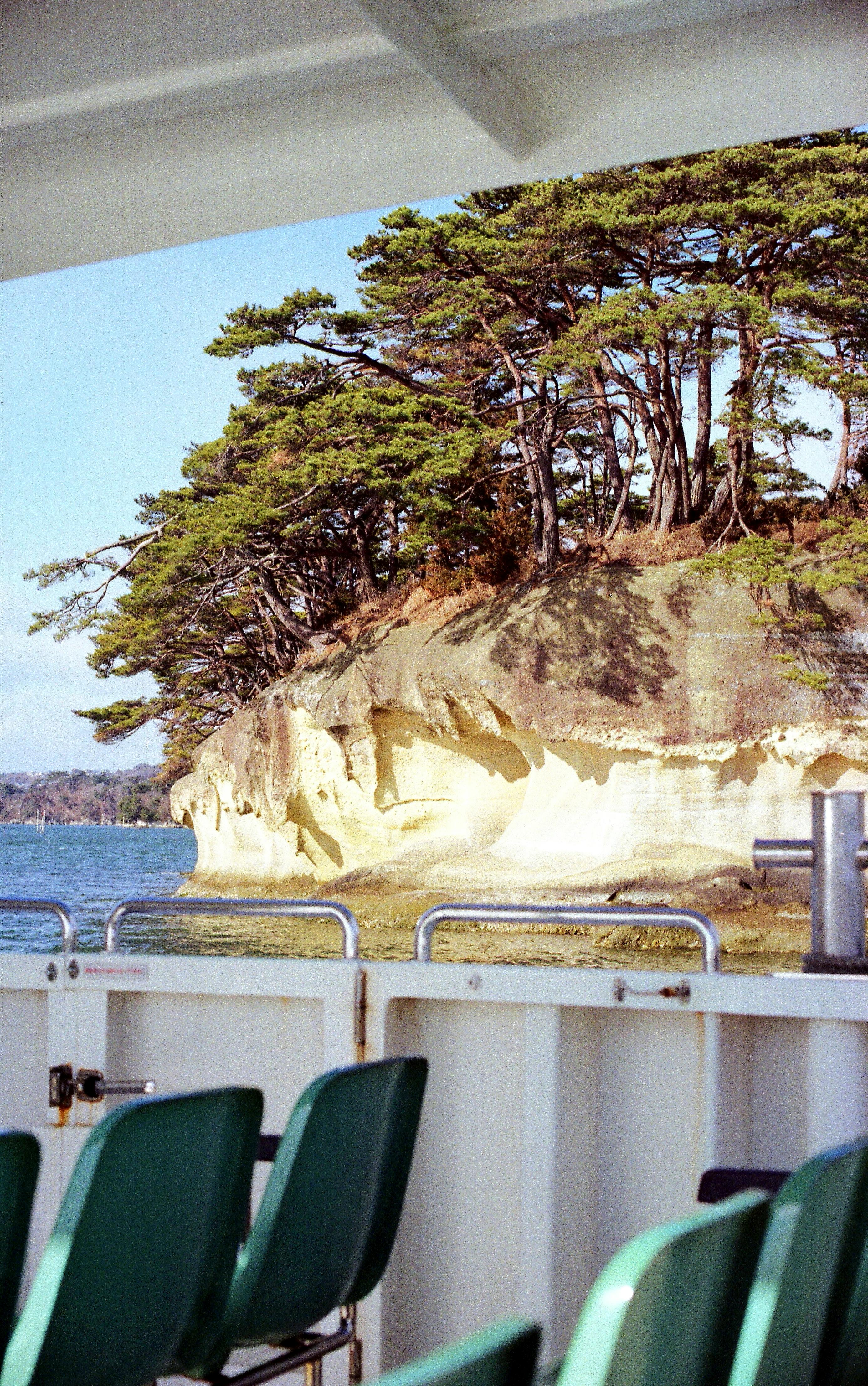 Experience the stunning coastal views of Matsushima Bay from a ferry, capturing serene islands and clear blue waters.