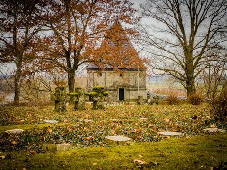 Peaceful scene of a military cemetery in Hofkirchen, Bavaria, surrounded by autumn trees.
