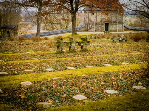 Free Serene view of a historic cemetery with stone crosses and an old chapel surrounded by autumn leaves. Stock Photo