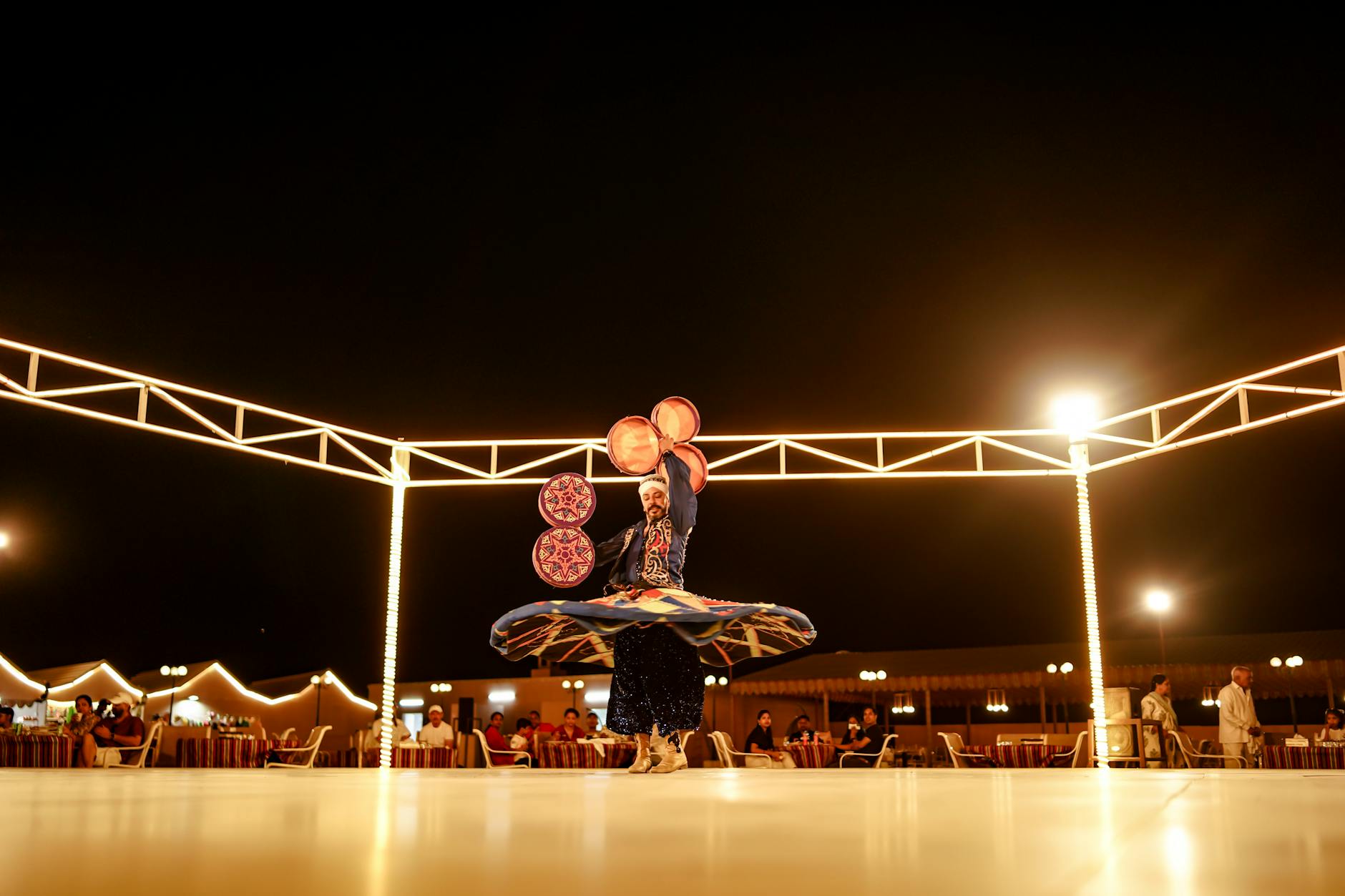 A mesmerizing Tanoura dance performed at an outdoor evening event in the UAE desert.