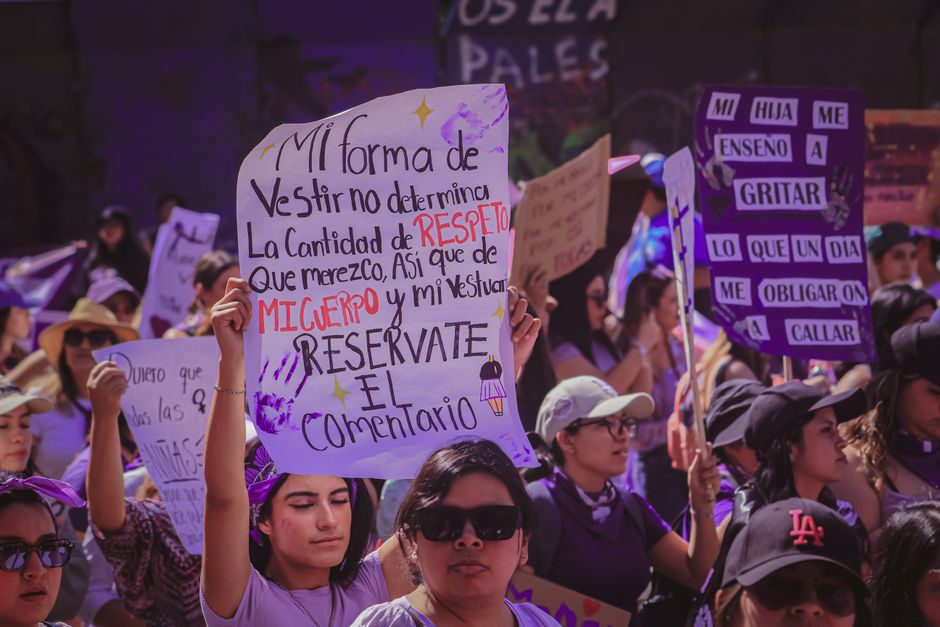 Mujeres en una protesta sosteniendo carteles que abogan por el respeto y el empoderamiento.