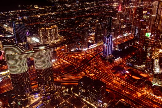 Breathtaking aerial view of Dubai cityscape at night with glowing skyscrapers and roads.