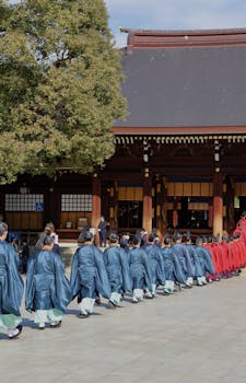 A traditional Japanese procession takes place at a shrine, showcasing cultural attire and ceremony.