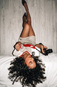 Modern portrait of a woman with curly hair and stylish outfit, capturing a relaxed and artistic vibe.