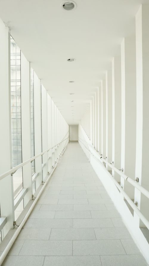 Free Bright minimalist indoor corridor with windows and railings, showcasing modern architecture. Stock Photo