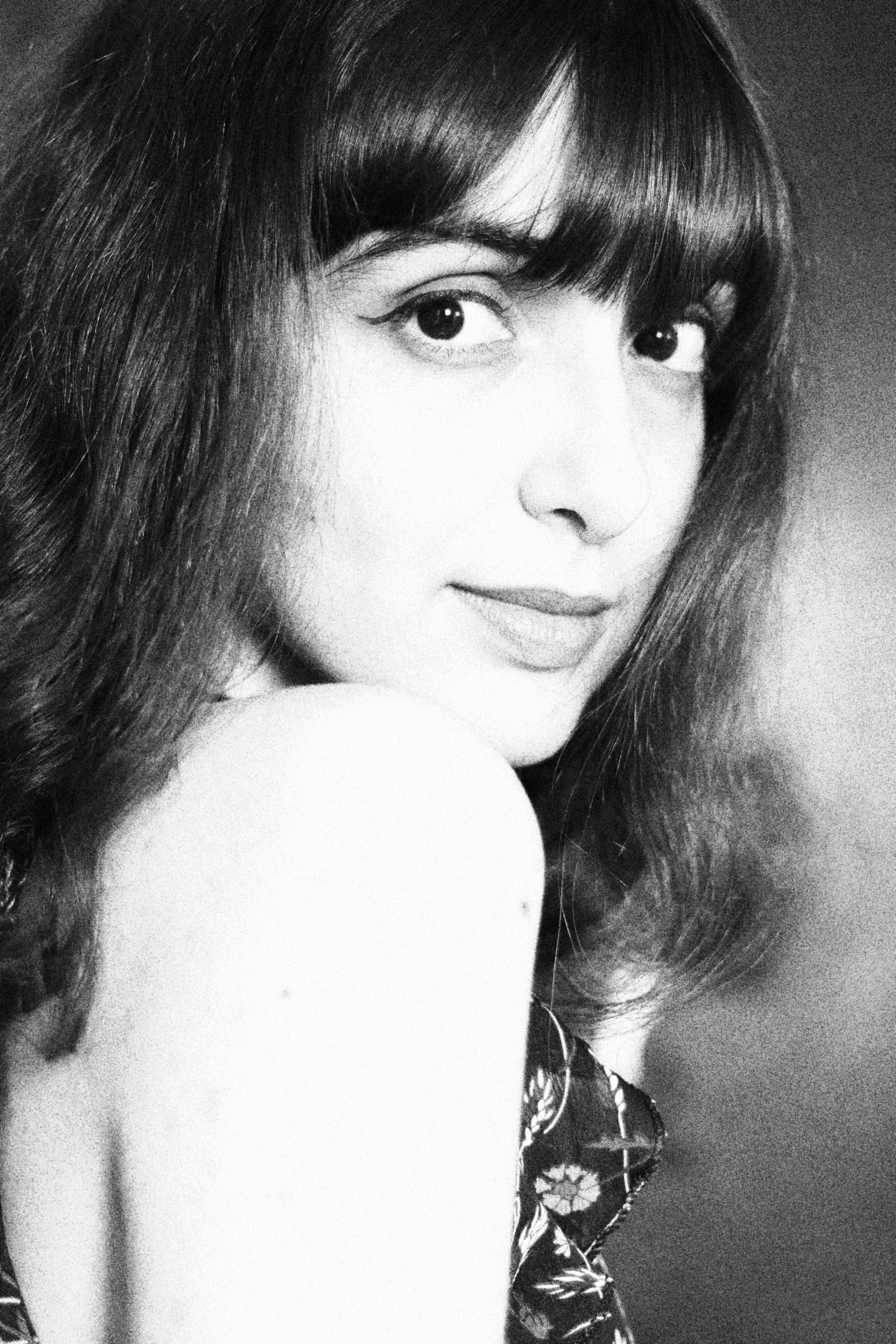 Artistic black and white portrait of a young woman with a serene expression.