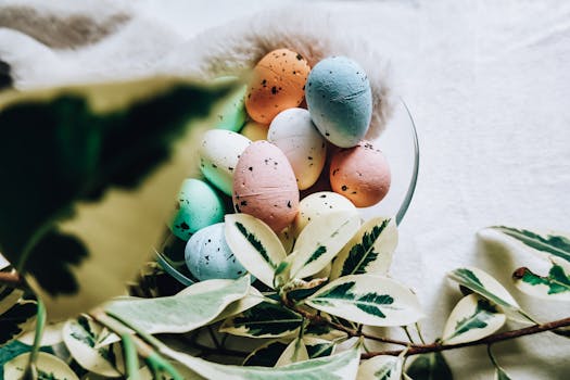 Aesthetic image of multicolored Easter eggs nestled in a leafy decoration, perfect for seasonal design.