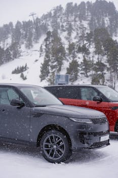 Luxury Range Rovers in a snowy Andorra landscape, showcasing winter adventure.