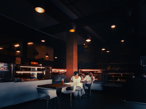 A dimly lit cafe with people enjoying a quiet conversation, creating a cinematic atmosphere.