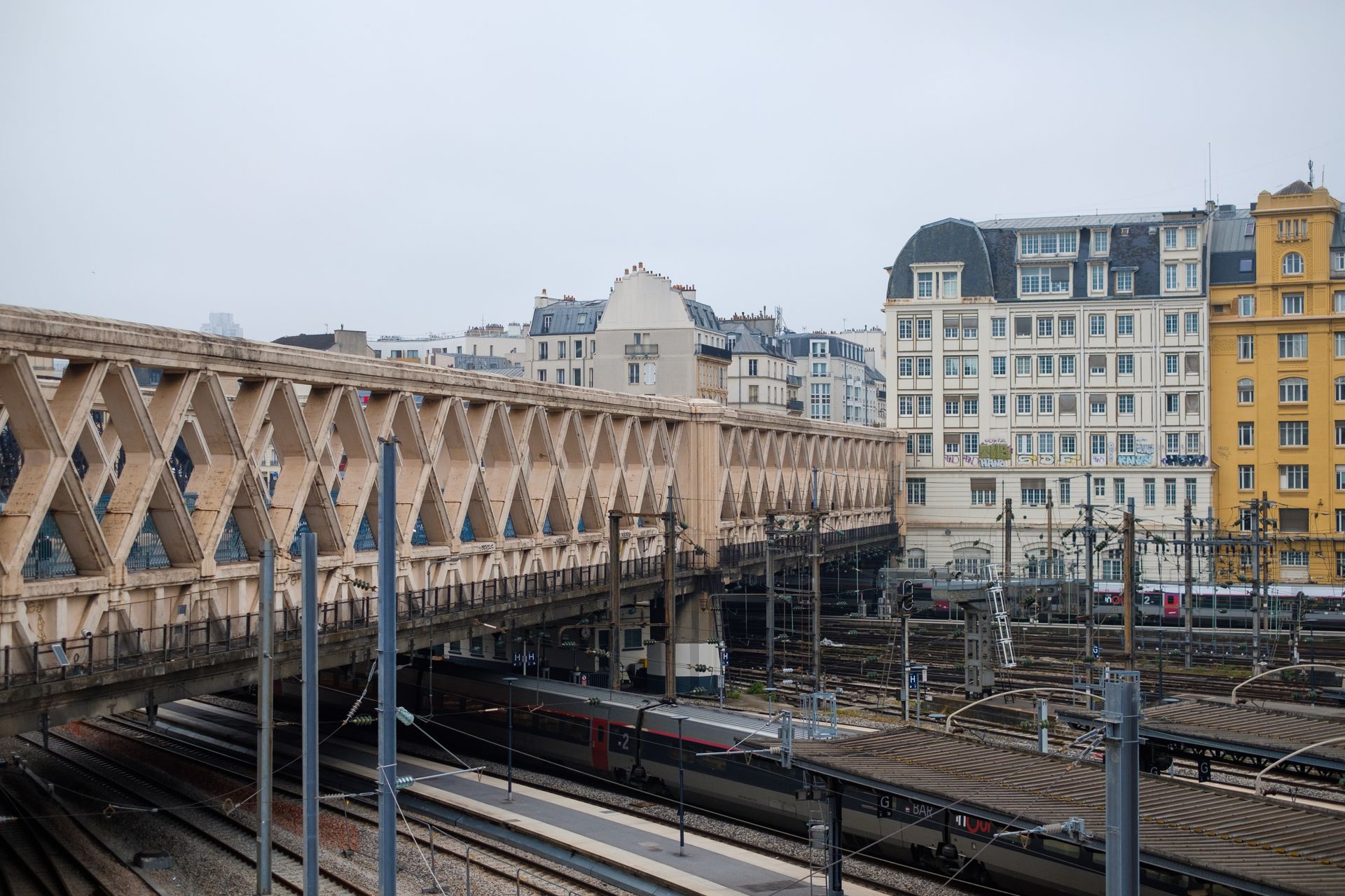 A view of a Paris train station showcasing classic French architecture and railway lines.