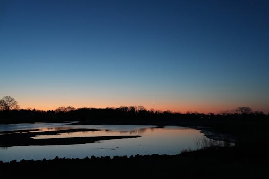 Tranquil sunrise over Cove Island Park, Stamford, capturing the peaceful morning sky and crescent moon reflection.