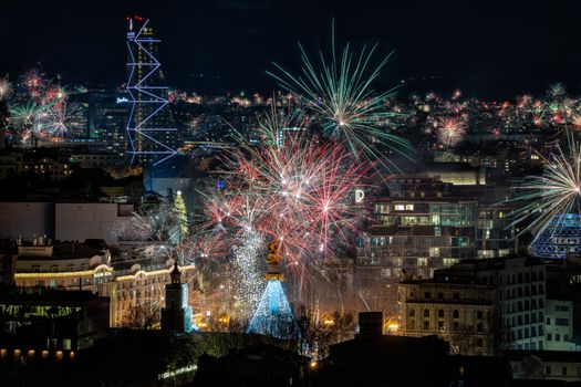 Spectacular fireworks lighting up the night sky over Tbilisi's vibrant cityscape.