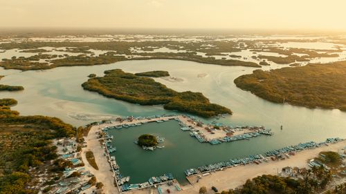 Free Aerial view of coastal wetlands with scattered islands and boats docked at sunset. Stock Photo