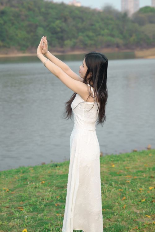 Woman in White Dress Posing by a Lake Outdoors · Free Stock Photo