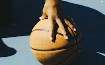 Close-up of Hand on Basketball in Sunlight