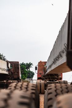 Heavy trucks transporting large concrete beams in Federal Capital Territory, Nigeria, showcasing industrial logistics.