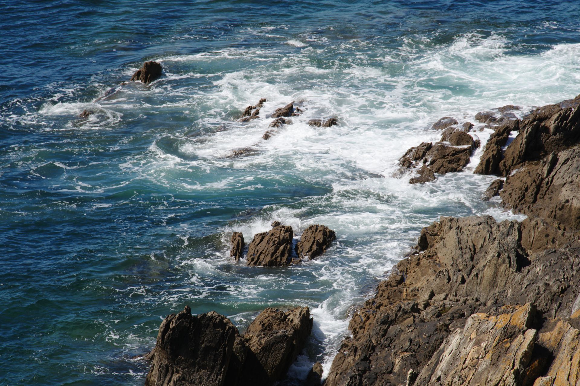 Captivating view of rocky Breton coastline with powerful waves crashing against the shore.