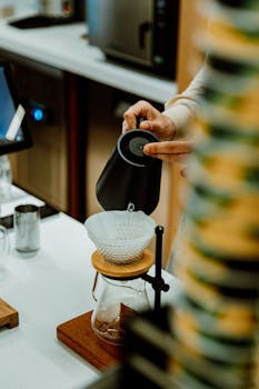 Barista preparing pour-over coffee at a trendy cafe in Baku, Azerbaijan.