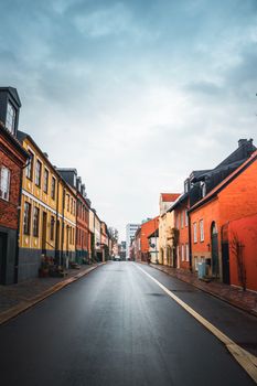 Vibrant street in Helsingborg, Sweden featuring colorful buildings under a cloudy sky.