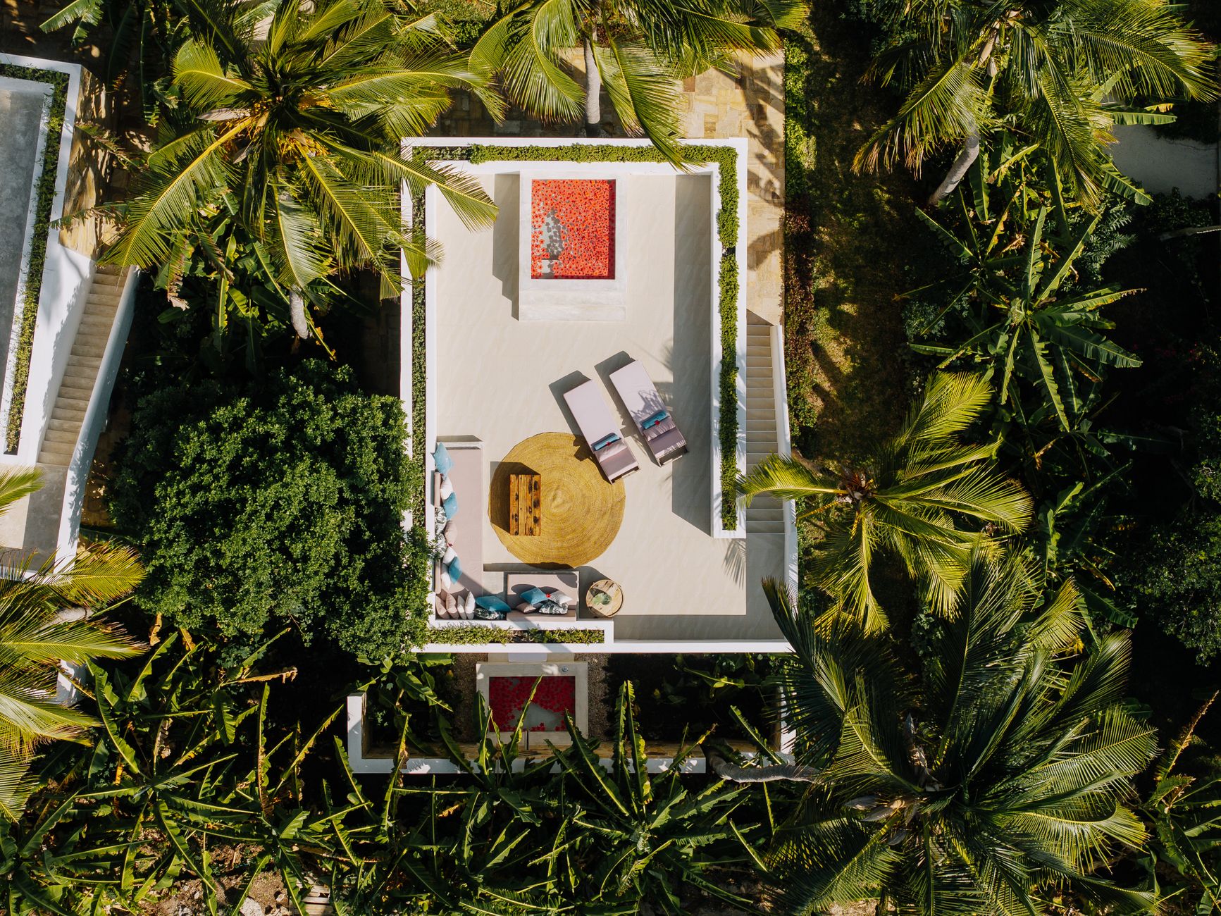 Aerial view of a luxurious tropical resort in Zanzibar, surrounded by lush palm trees.
