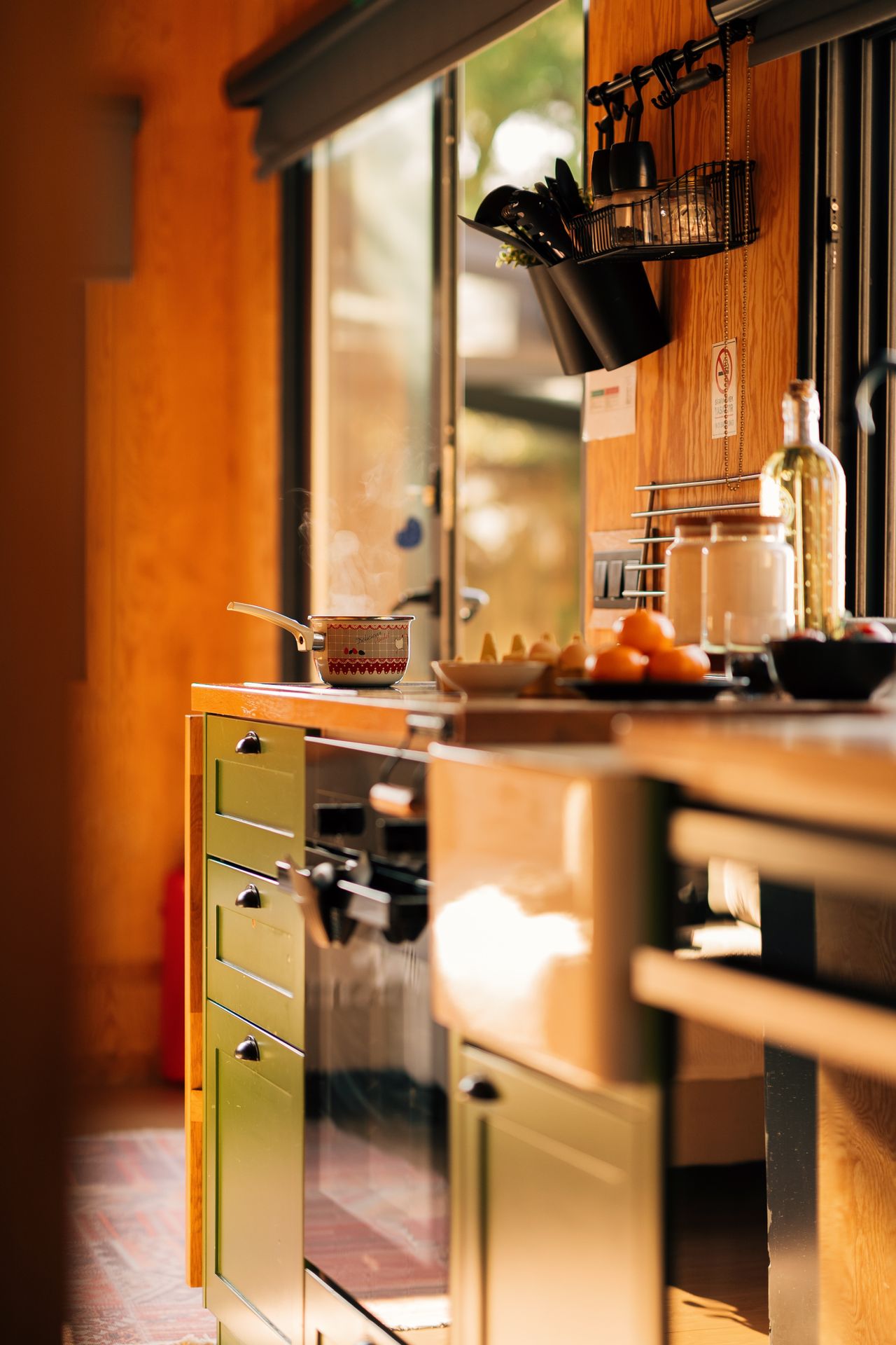 sage-green-kitchen-cabinets Green kitchen drawers with wooden panels in warm light