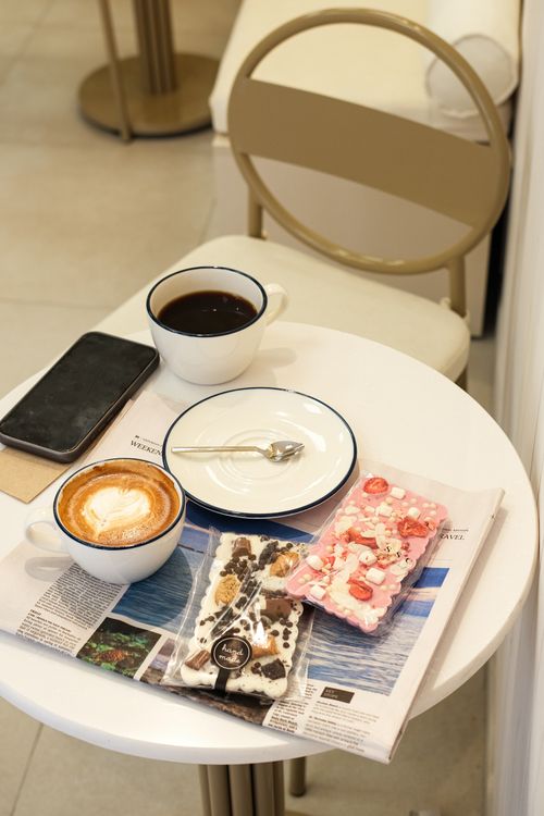 Free A cozy café table with coffee cups, a smartphone, and snacks in Büyükçekmece, Istanbul. Stock Photo
