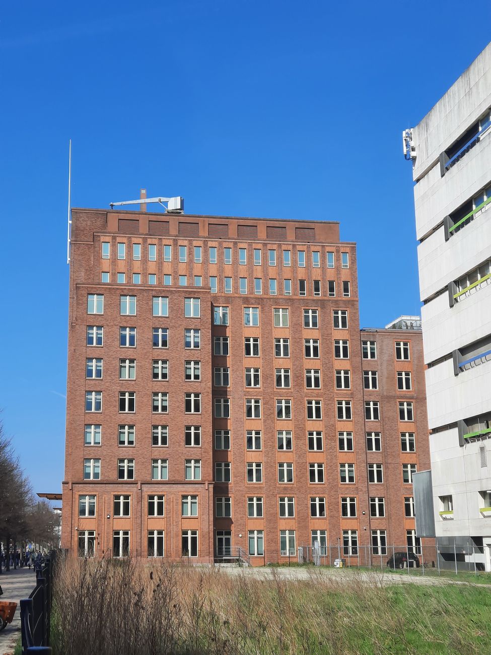 Een klassiek rood bakstenen gebouw in Den Haag tegen een strakblauwe lucht, een toonbeeld van stedelijke architectuur.