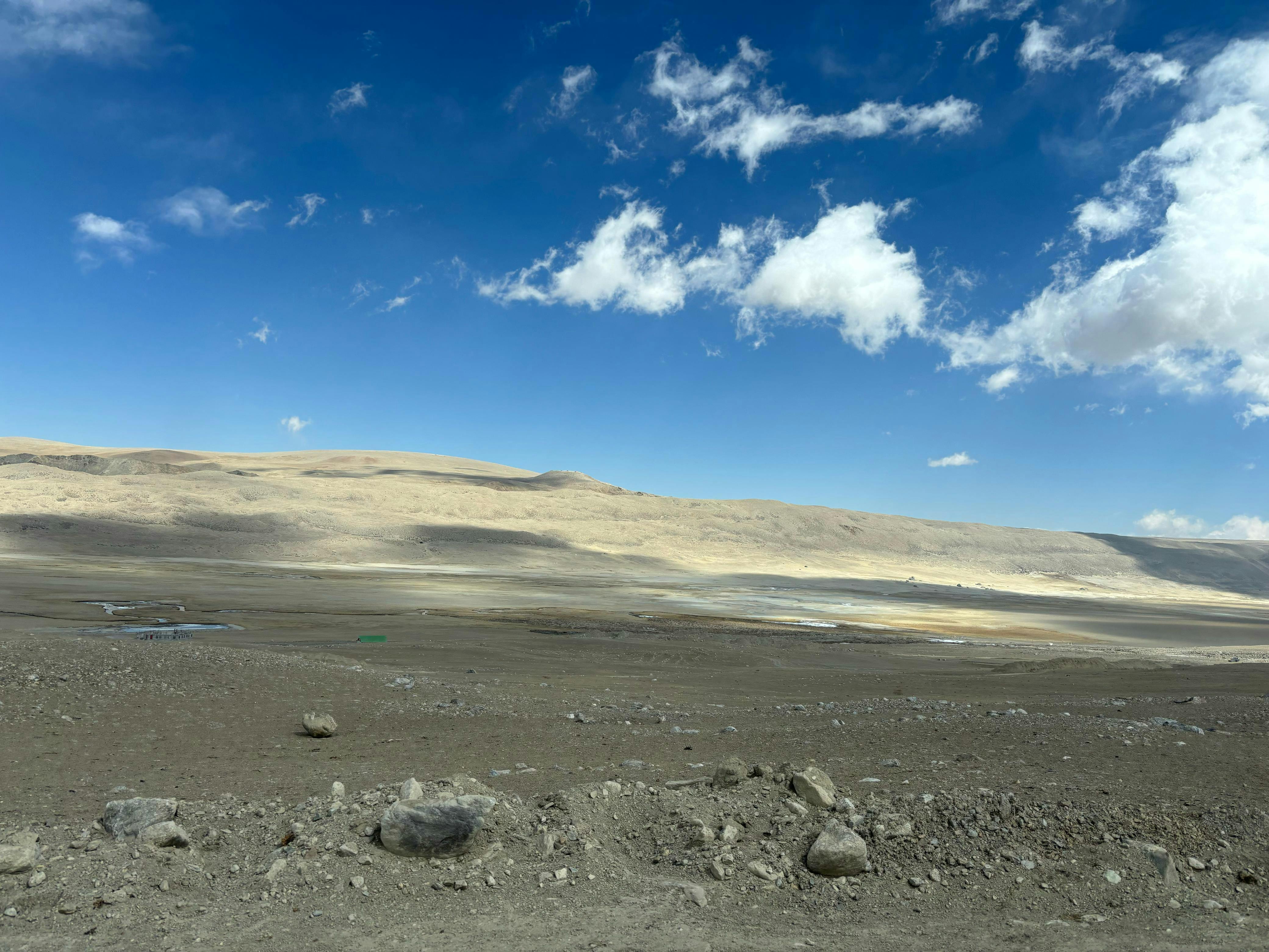 Expansive view of a barren desert landscape under a clear blue sky in India.