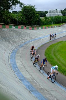 Cyclists compete at a vibrant velodrome in Curitiba, Brazil, showcasing speed and skill.