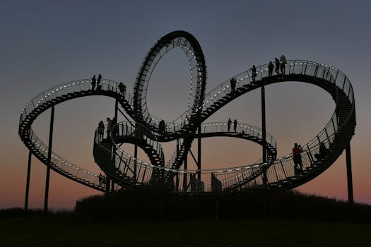 Silhouette of people walking on a spiral staircase against a mesmerizing sunset.