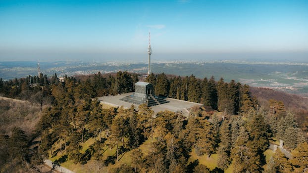 A stunning aerial shot of Avala Tower and Monument surrounded by lush greenery in Beli Potok, Serbia during spring.