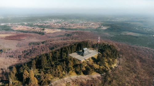 Free Drone view of Avala Tower surrounded by forested hills in Beli Potok, Serbia during spring. Stock Photo