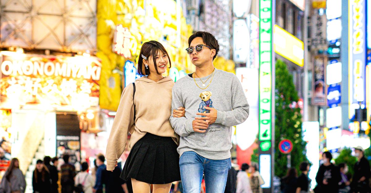 Rüyada Sevgiliyle Telefonlaşmak - Rüya Tabiri ve Anlamı - A young couple enjoys a night walk across the vibrant Shibuya Crossing in Tokyo, Japan.