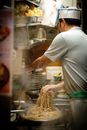 Japanese chef cooking authentic ramen noodles in a traditional Tokyo kitchen, showcasing culinary skills.