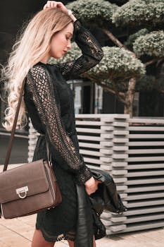 Stylish young woman with leather bag in an urban setting, showcasing elegant fashion and modern style.
