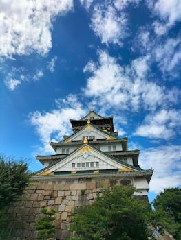 A stunning view of Osaka Castle in Japan set against a vibrant blue sky.