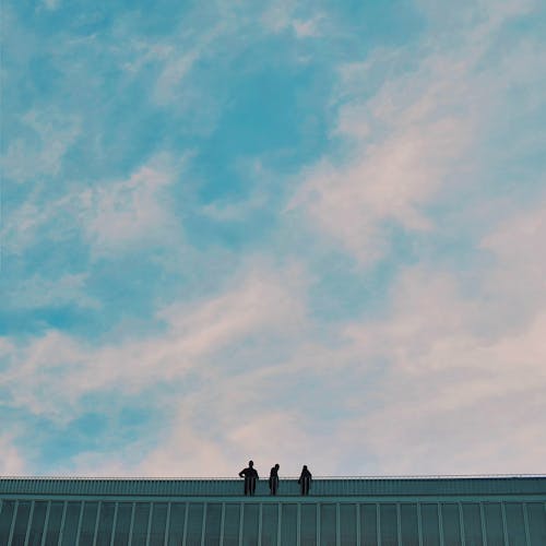 Prise De Vue En Angle De La Silhouette De Personnes Au Sommet Du Bâtiment