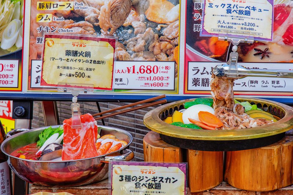 Realistic plastic food models on display at a Tokyo market stall featuring traditional dishes.