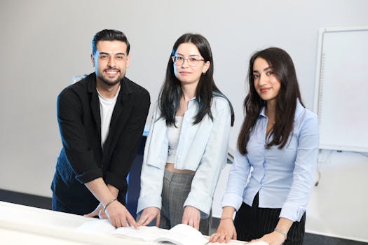 Three young professionals collaborating at a desk in an office setting.