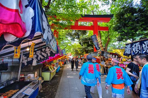 Free Lively scene at a traditional Japanese street festival in Tokyo with colorful stalls and visitors. Stock Photo