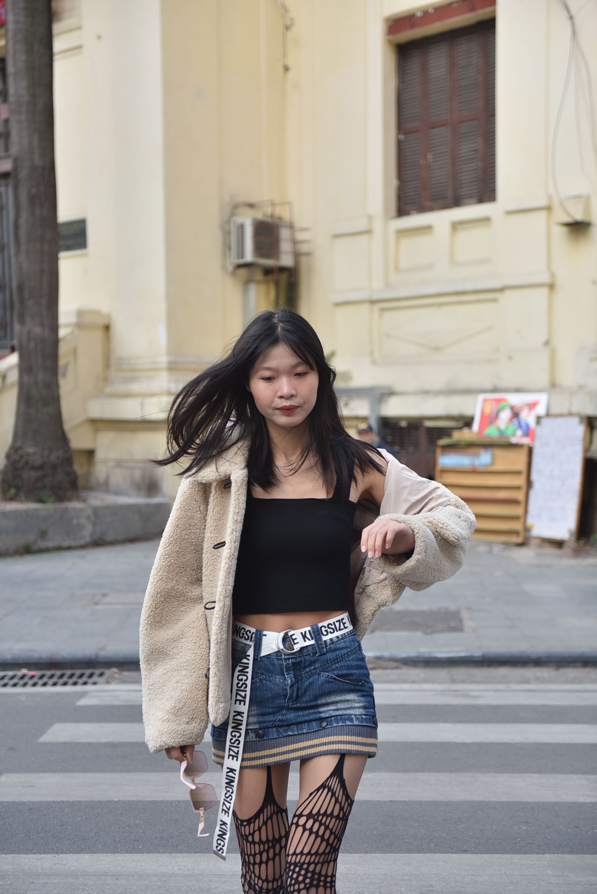 A fashionable woman crossing an urban street