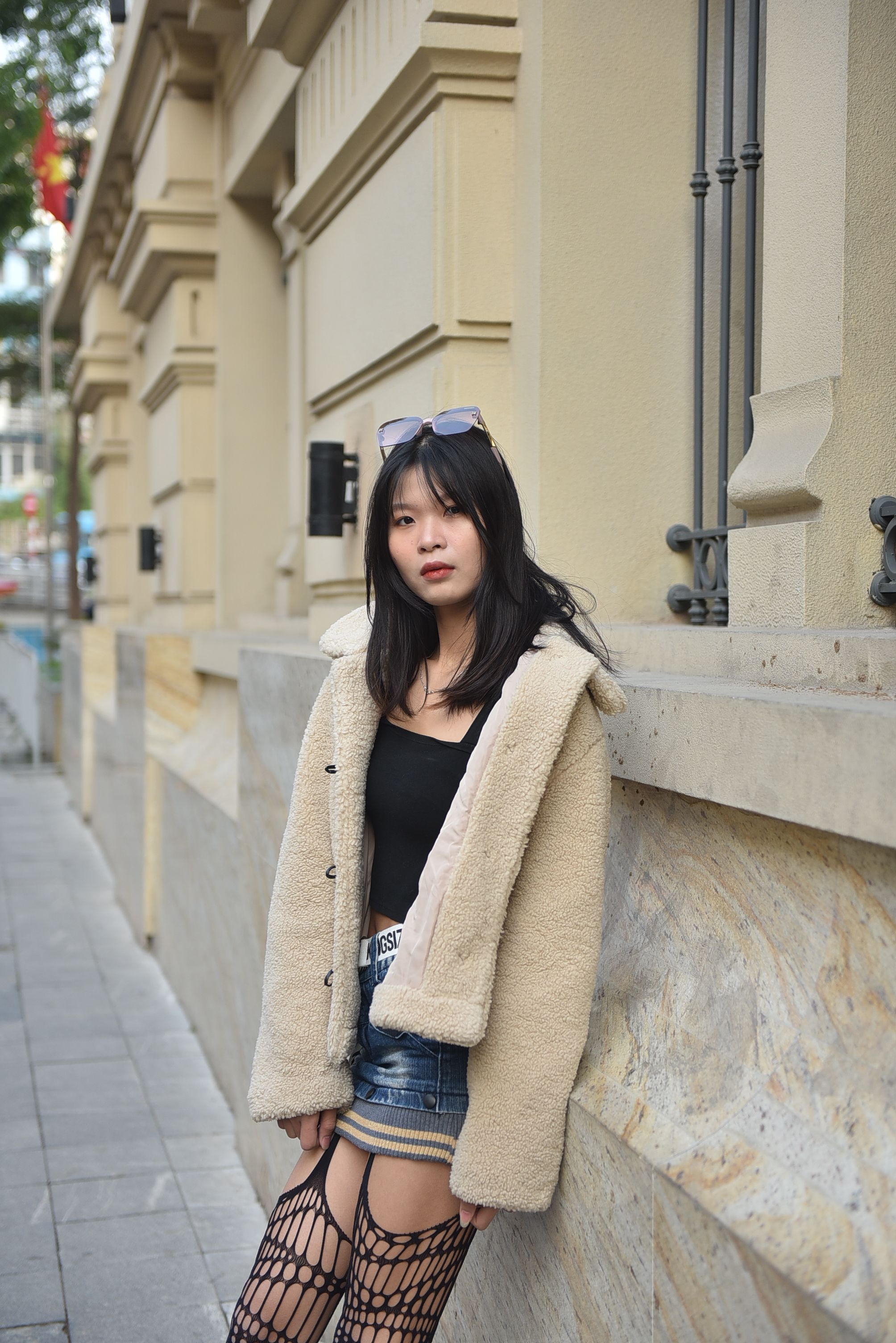 Young woman in stylish outfit posing outdoors in an urban setting.