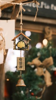 Hanging ornament with Japanese anime character, rustic style, holiday season decor.