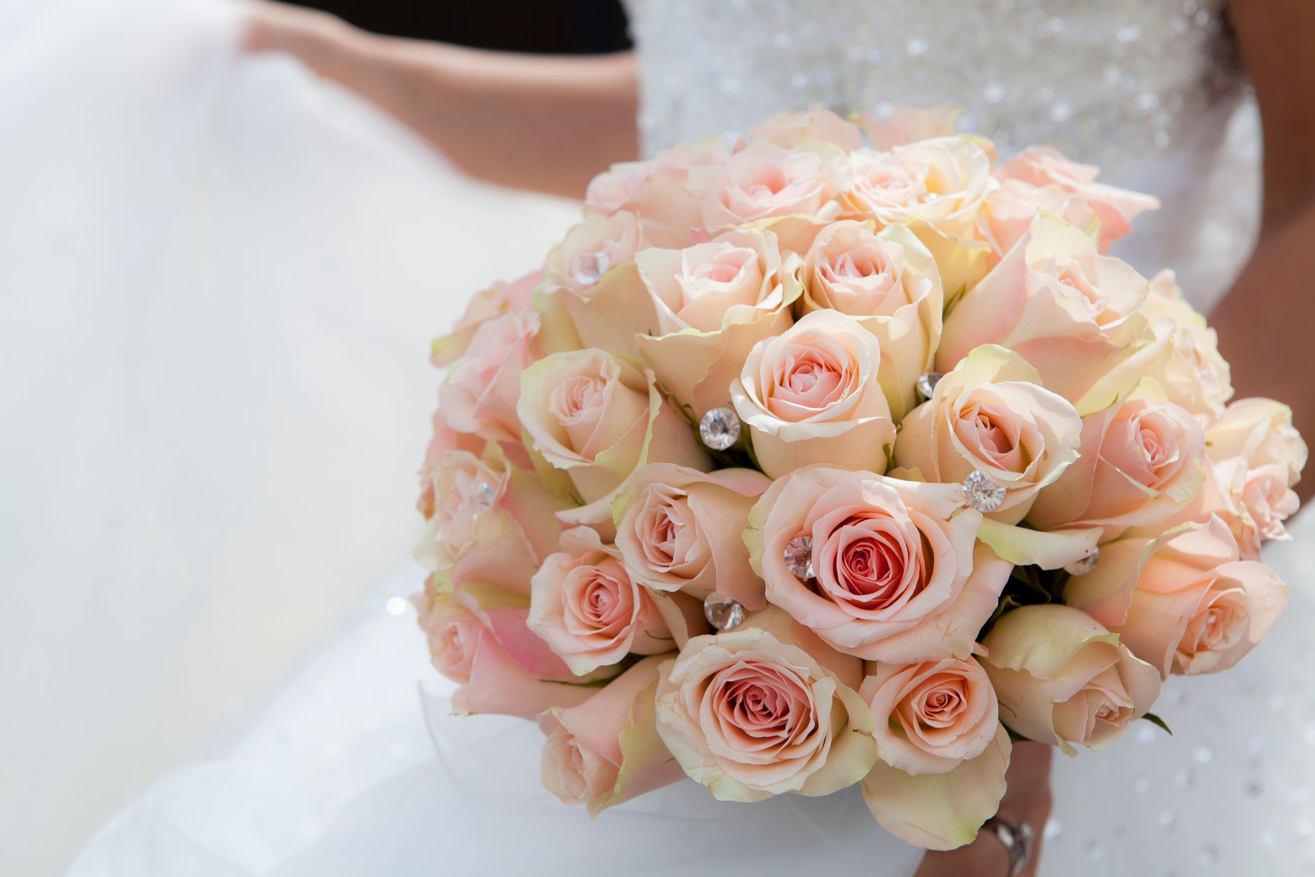 A stunning bridal bouquet of pink roses held by a bride in a wedding dress, symbolizing love.