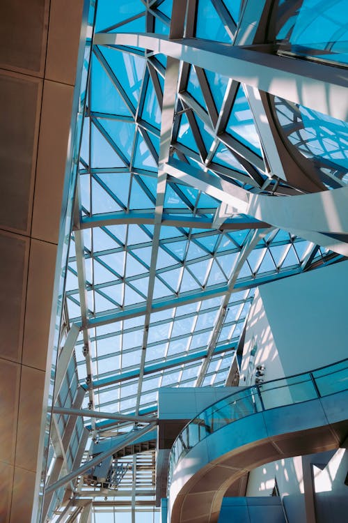 低角度拍攝的帶有鋼和玻璃面板天花板的現代建築