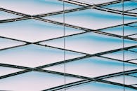 低角度视角下，以蓝天为背景的现代几何金属结构