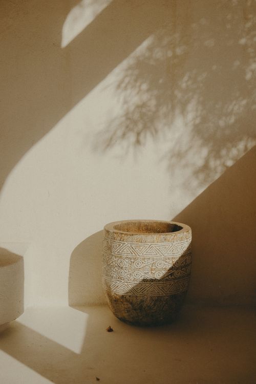 Free An artistic capture of a ceramic pot adorned with Moroccan patterns in natural sunlight. Stock Photo