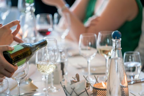 Person Pouring Wine on Clear Wine Glass