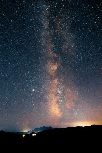 Milky Way glowing over a mountain lake by Nikita Pishchugin on Pexels